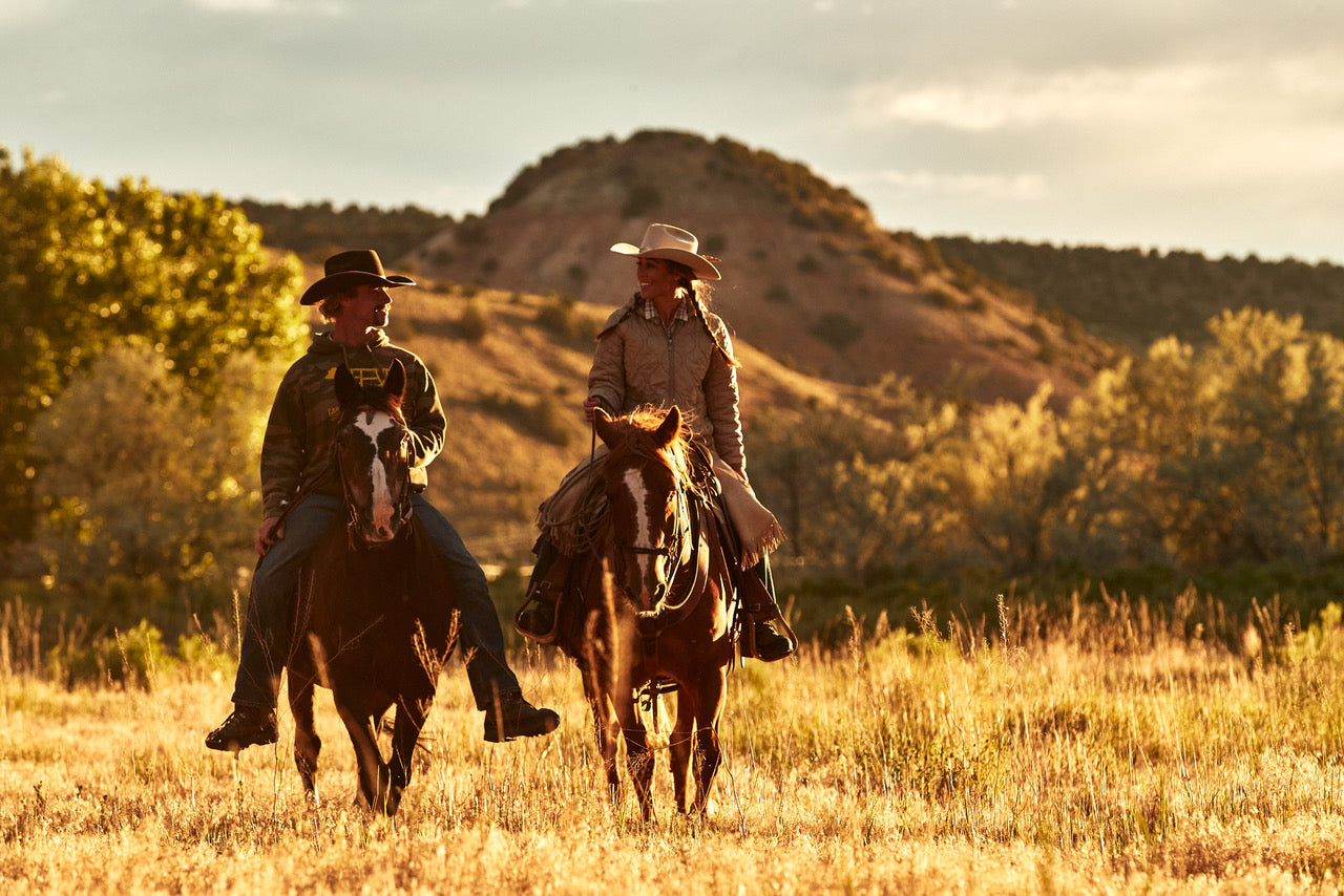 Annia and RC Carter on horseback on the open range