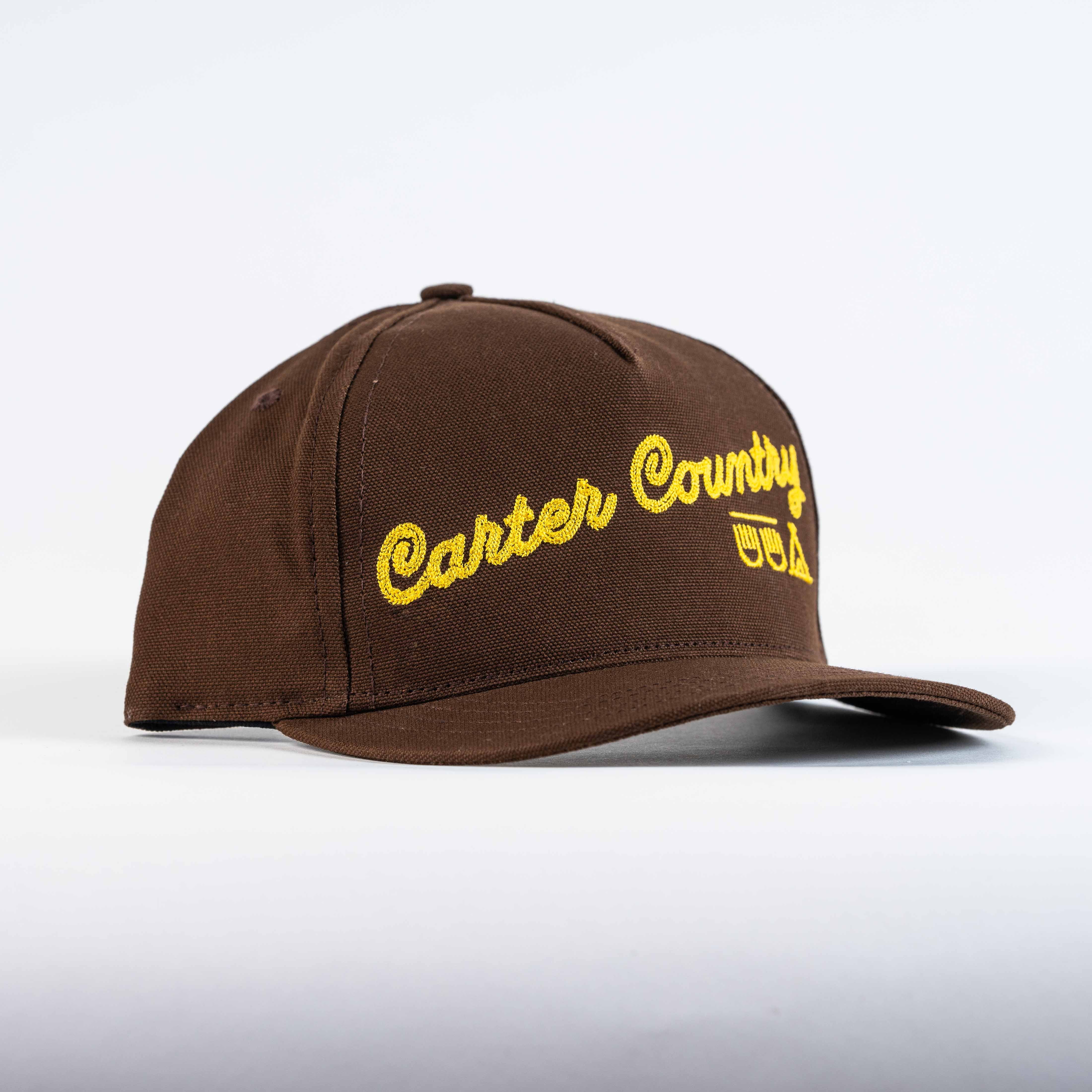Brown trucker cap with yellow Carter Country stitch and Ten Sleep in native american symbols