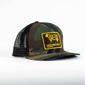 angled front view camo trucker cap with yellow and brown patch including cow outline and carter country meats wyoming usa