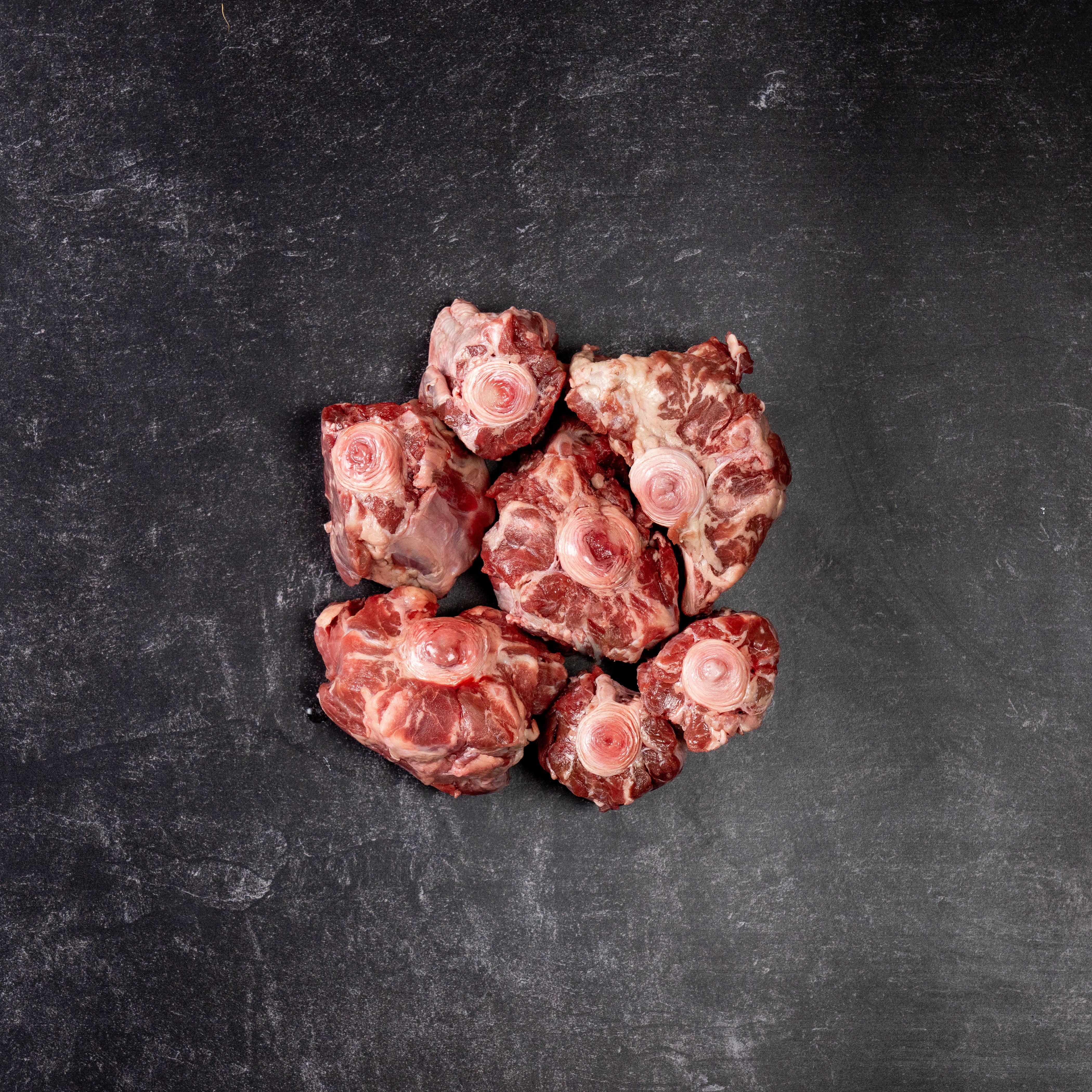 Small pile of oxtail cut of beef on a slab