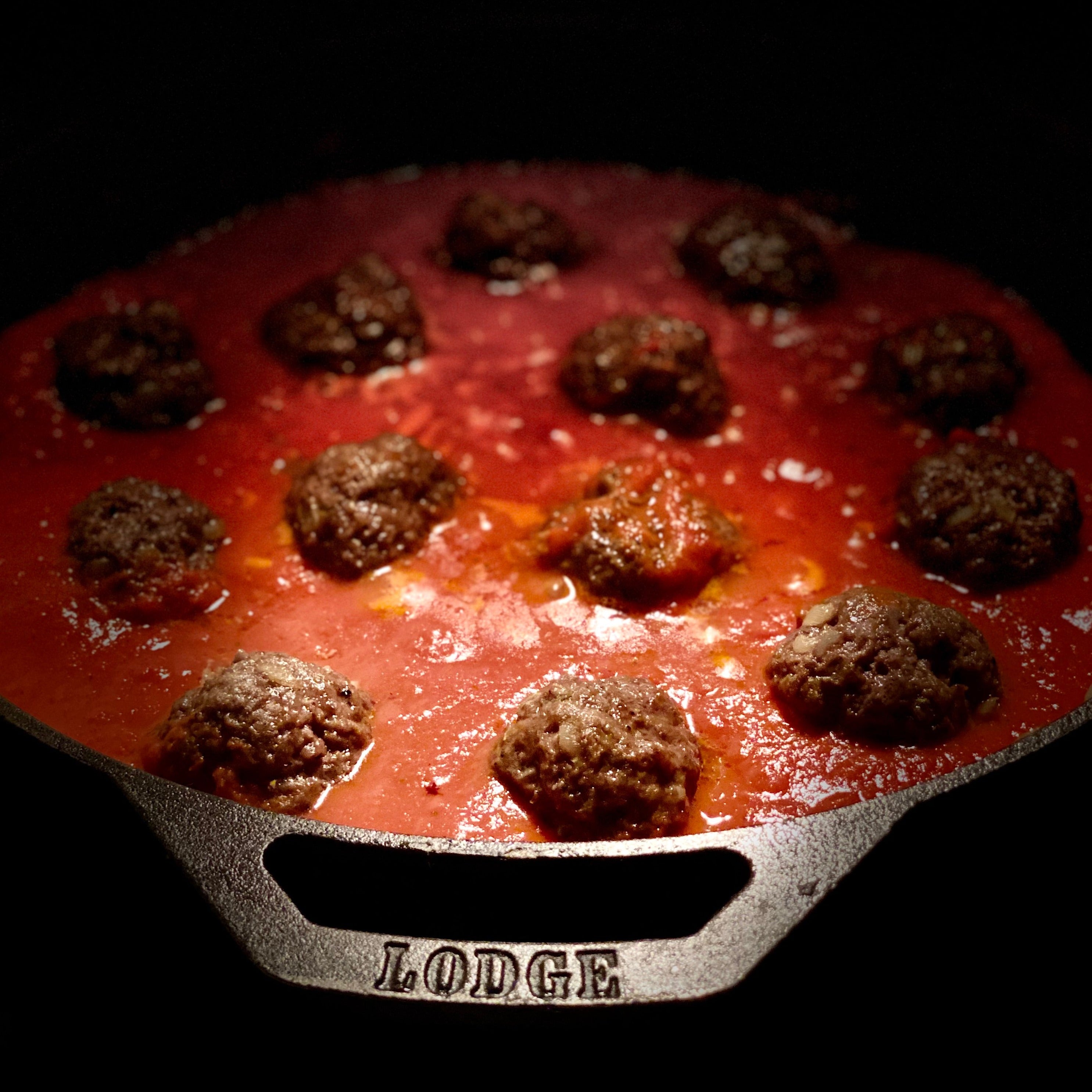 Cooked meatballs in tomato sauce in cast iron pot