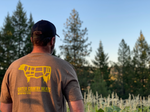 Rear modeled view of CCM brown standard co tee with cow outline in yellow and Carter Country Meats in yellow text below